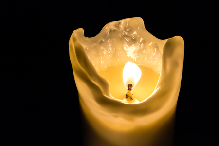 One candle flame at night isolated on black backgroundの写真素材