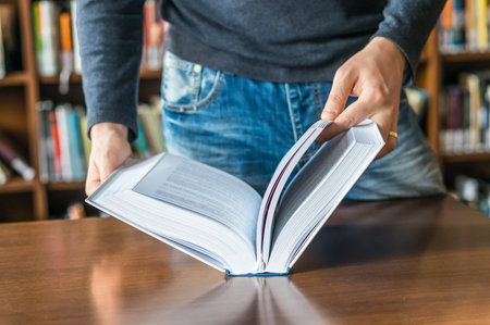 The man opening and browsing the book pages in library