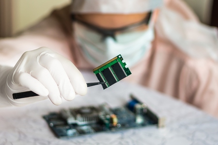 Young scientist repairs electronic circuit and holding damaged electrical componentの写真素材