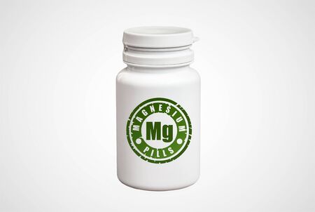 Bottle of pills with magnesium Mg on white backgroundの写真素材