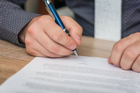Businessman is signing a contract to conclude a deal - business conceptの写真素材
