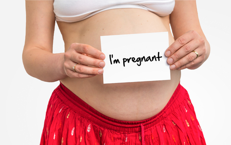Pregnant woman with inscription: I'm pregnant on her bellyの写真素材