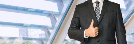 Man in business suit showing symbol OK in officeの写真素材