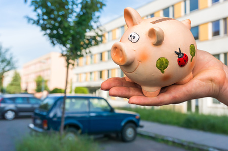 All savings money from pink ceramic piggy bank to pay for the dream home and car on blurred backgroundの写真素材