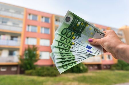 Property buyer holding euro banknotes and buying beautiful flat from real estate agencies on blurred backgroundの写真素材