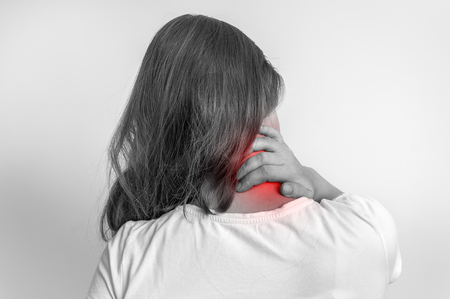 Woman with muscle injury having pain in her neck - black and white photoの写真素材