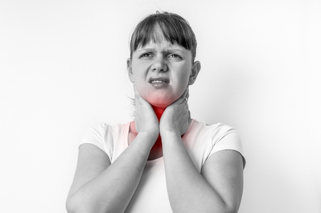 Woman with throat sore is holding her aching throat - black and white photoの写真素材