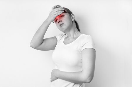 Woman with headache or migraine is holding her aching forehead - black and white photoの写真素材