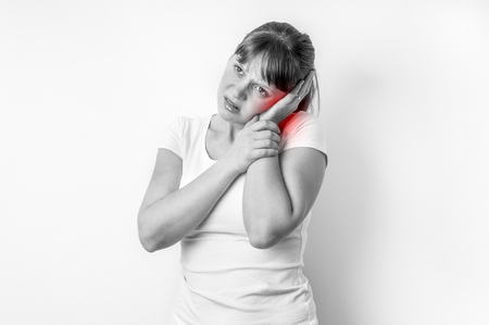 Woman with earache is holding her aching ear - black and white photoの写真素材