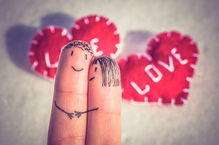 Happy fingers on a snow beautiful background with two hearts - retro and vintage styleの写真素材