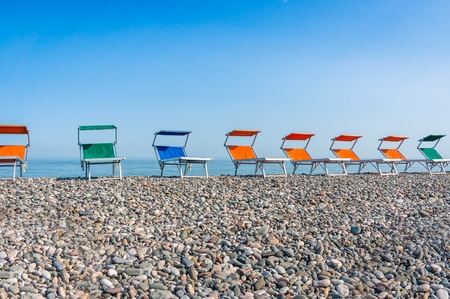 Colorful beach chairs on the shingle beach near seaの写真素材