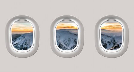 Looking out the windows of a plane to the winter mountains and sunset in Czech Republicの写真素材