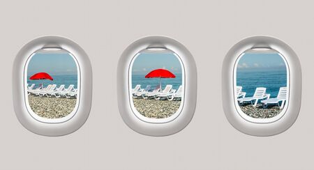 Looking out the windows of a plane to the sunbeds and red umbrella, holidays conceptの写真素材