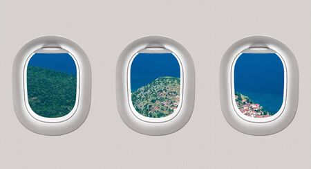 Looking out the windows of a plane to the sea bay, view from aboveの写真素材