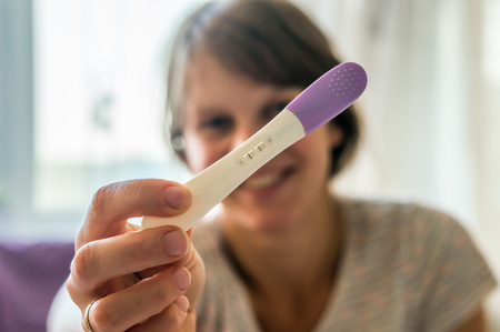 Woman holding positive pregnancy testの写真素材