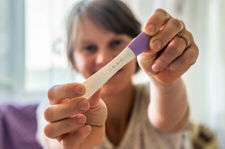 Woman holding positive pregnancy testの写真素材