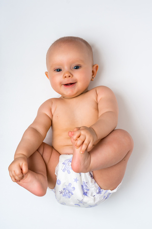 Adorable baby girl lying on back isolated on white backgroundの写真素材