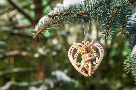 Christmas heart with angel on snowy Christmas tree branchの写真素材