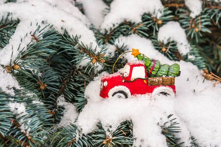Toy car with Christmas tree on snowy branch fir, Xmas conceptの写真素材