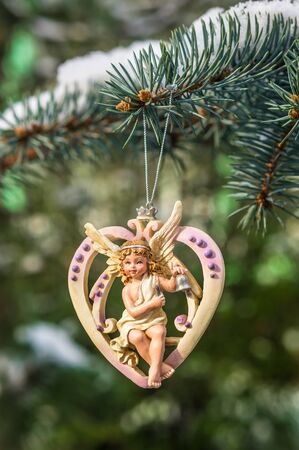 Christmas heart with angel on snowy Christmas tree branchの写真素材