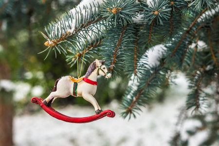 Rocking horse and snowy pine tree decorated for Christmas toy on branch