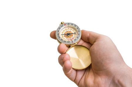 Antique brass compass in a hand isolated on white backgroundの写真素材