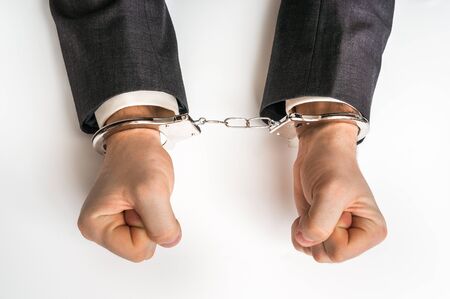 Male hands in handcuffs isolated on white backgroundの写真素材