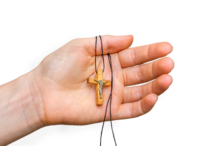 Wooden cross in female hand isolated on white background - religion conceptの写真素材