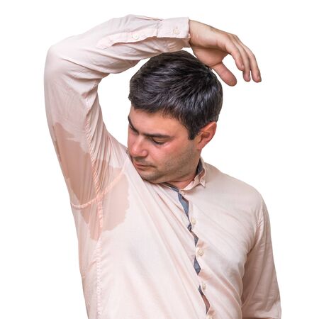 Young man with sweating under armpit in pink shirt isolated on whiteの写真素材