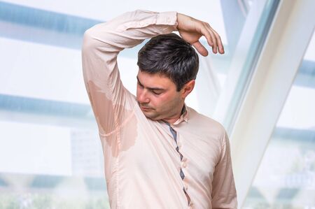 Business man with sweating under armpit in pink shirtの写真素材