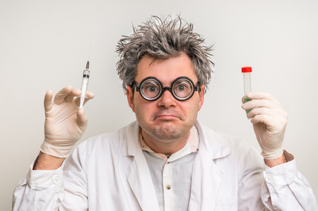 Crazy scientist with gray hair performing experiments in laboratoryの写真素材