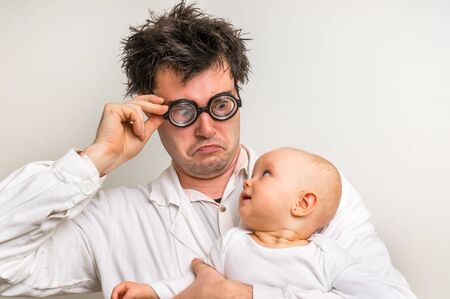 Crazy doctor with newborn baby in his hands - healthcare conceptの写真素材