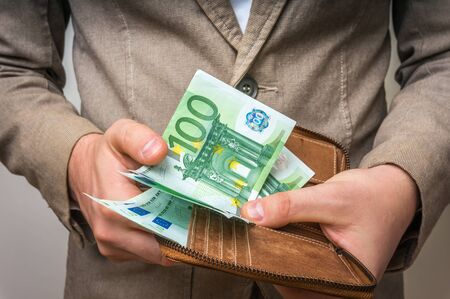 Businessman hands holding wallet with stack of euro bills moneyの写真素材