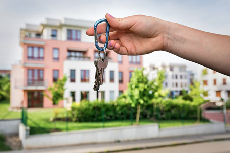 Real estate agent giving flat keys to a new property owner on blurred backgroundの写真素材