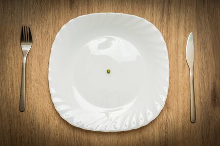 One green pea on white plate - diet conceptの写真素材