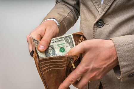 Man holding leather wallet with only one dollar insideの写真素材