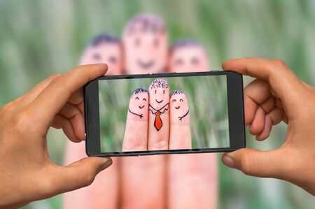 Woman hands with mobile cell phone to take a photo of happy fingersの写真素材