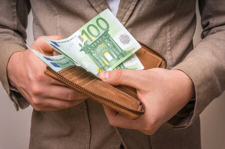Businessman hands holding wallet with stack of euro bills moneyの写真素材