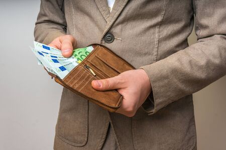 Businessman hands holding wallet with stack of euro bills moneyの写真素材