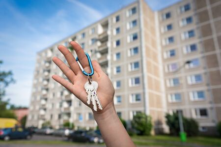 Real estate agent giving flat keys to a new property owner on blurred backgroundの写真素材