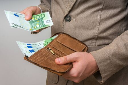 Businessman hands holding wallet with stack of euro bills moneyの写真素材