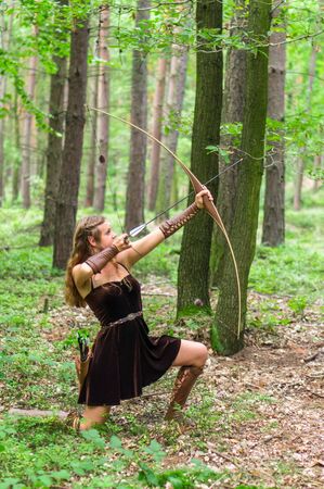 Young lady Elf with a long bow in the wild forestの写真素材