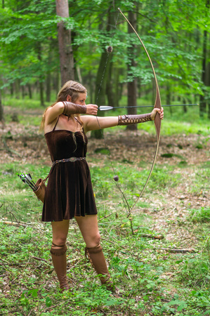 Young lady Elf with a long bow in the wild forestの写真素材