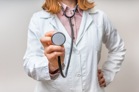 Close up of female doctor with stethoscope in the hands - medical conceptの写真素材