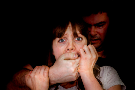 Man covering woman's mouth so she couldn't scream - abuse and violence conceptの写真素材