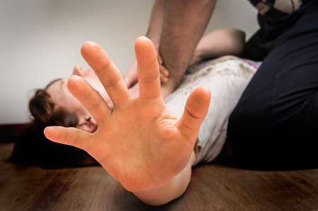 Man tries to strangle woman on the floor - domestic violence conceptの写真素材