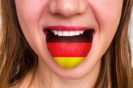 Woman with german flag on the tongue - learning a foreign languageの写真素材