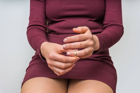 Disappointed woman taking off the wedding ring - divorce conceptの写真素材