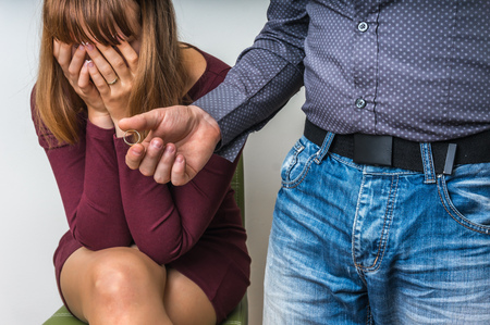 Disappointed man returning the wedding ring to his wife - divorce conceptの写真素材