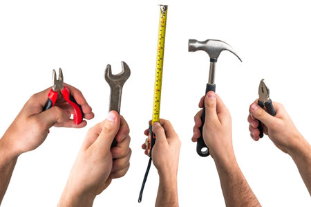 Wrench, pliers, tape measure and hammer in hands of workers isolated on white background
